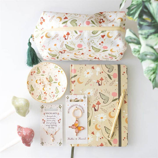 Floral-themed stationery items including a pouch, notebook, and jewelry on a white surface.