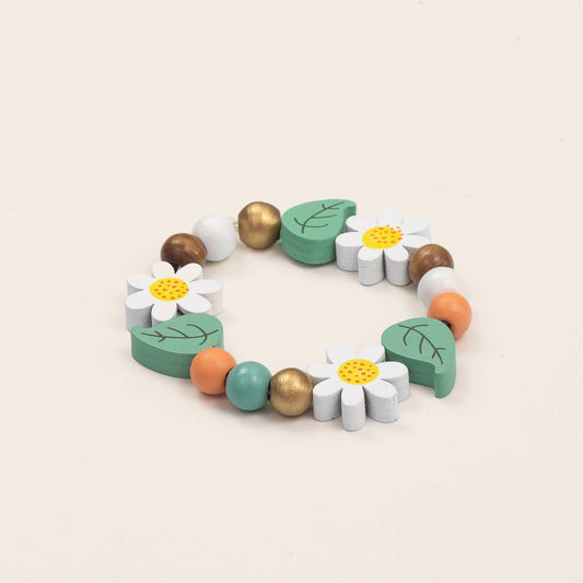 Colorful wooden bracelet with flowers and leaves on a beige background