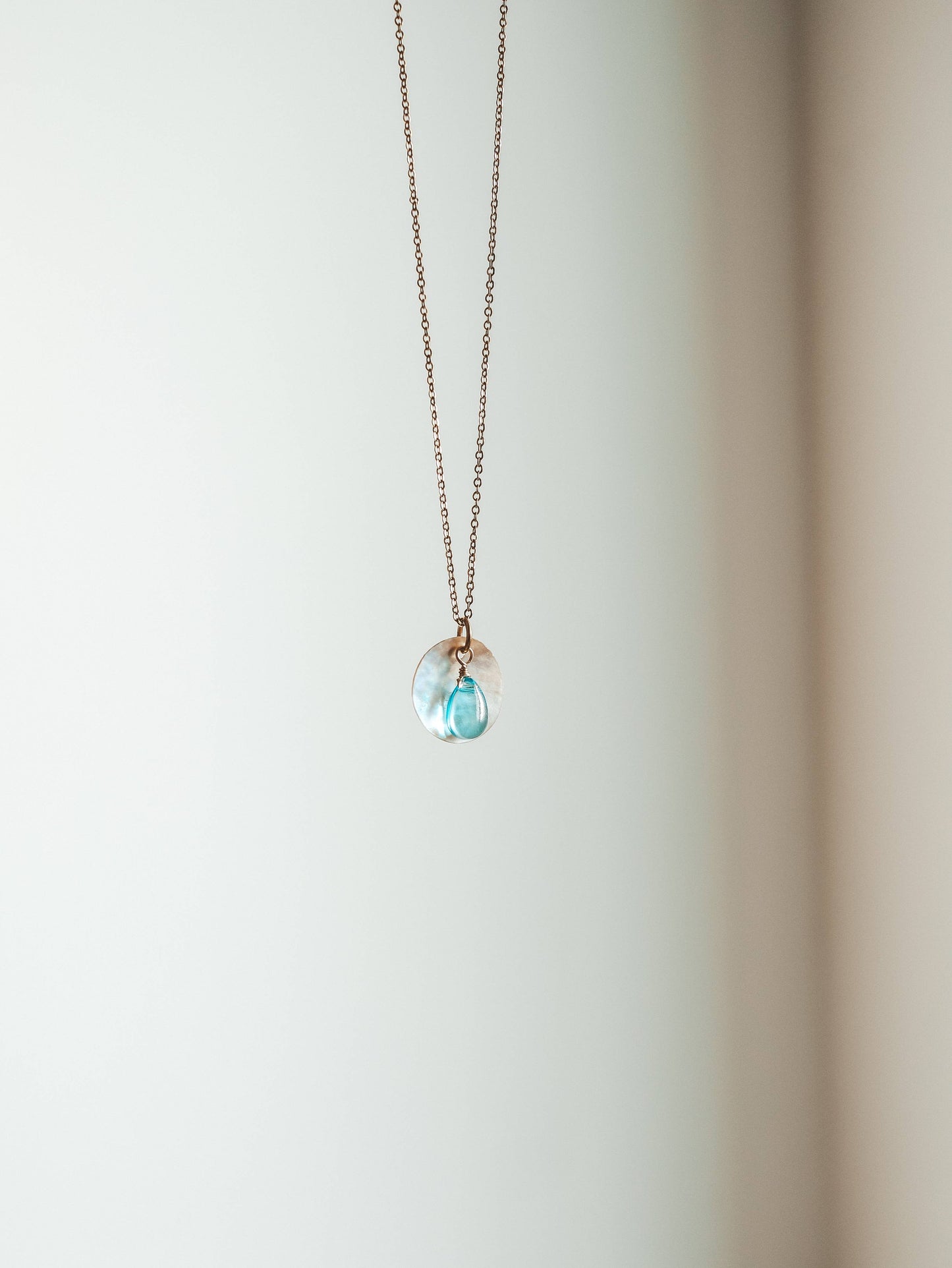 Necklace with a blue pendant on a white background