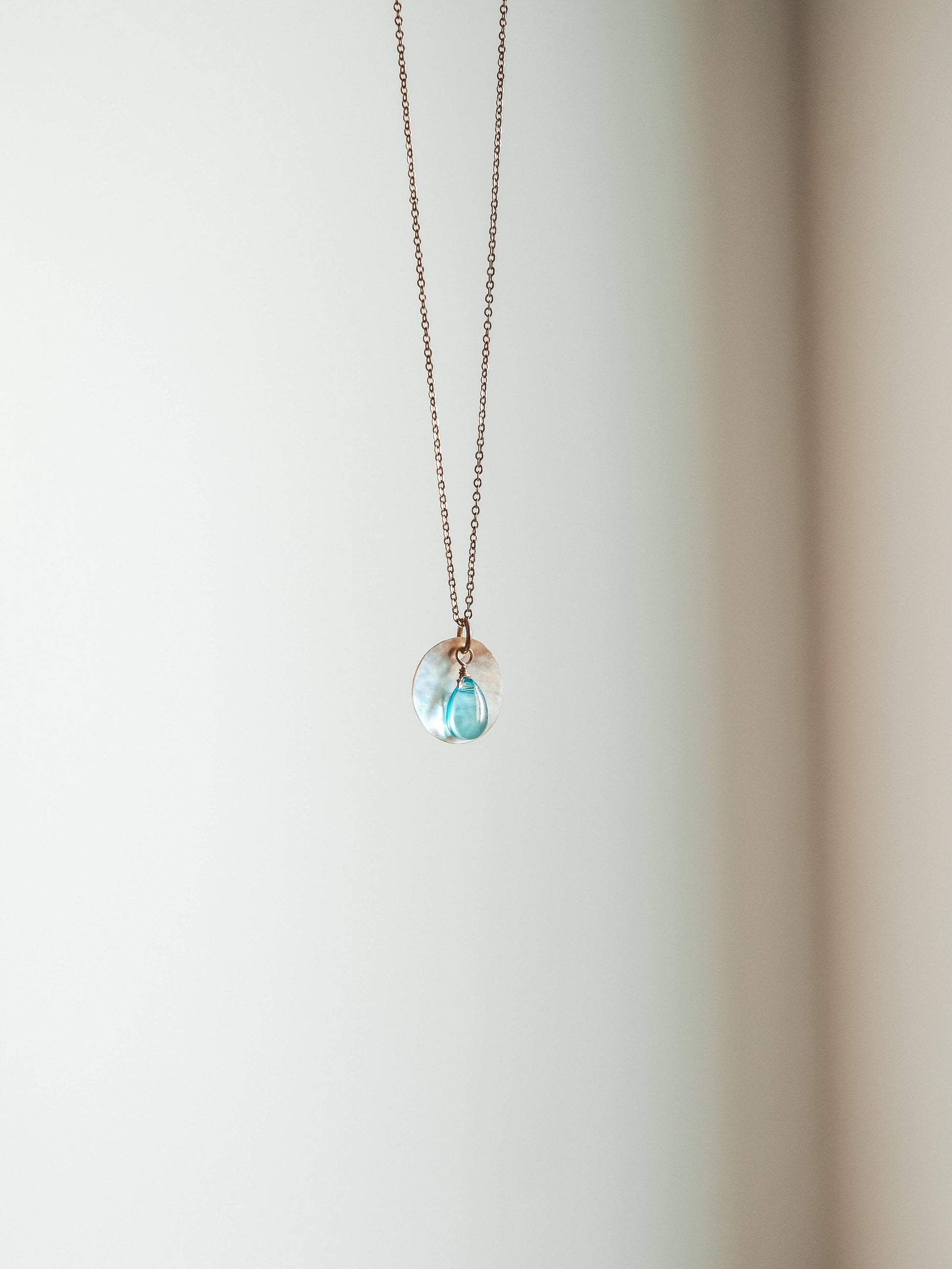 Necklace with a blue pendant on a white background