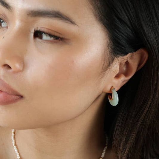 Close-up of a woman wearing a jade earring with gold accents.