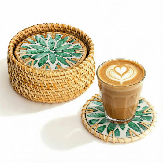 Woven coaster with green leaf pattern next to a glass of coffee on a matching coaster.