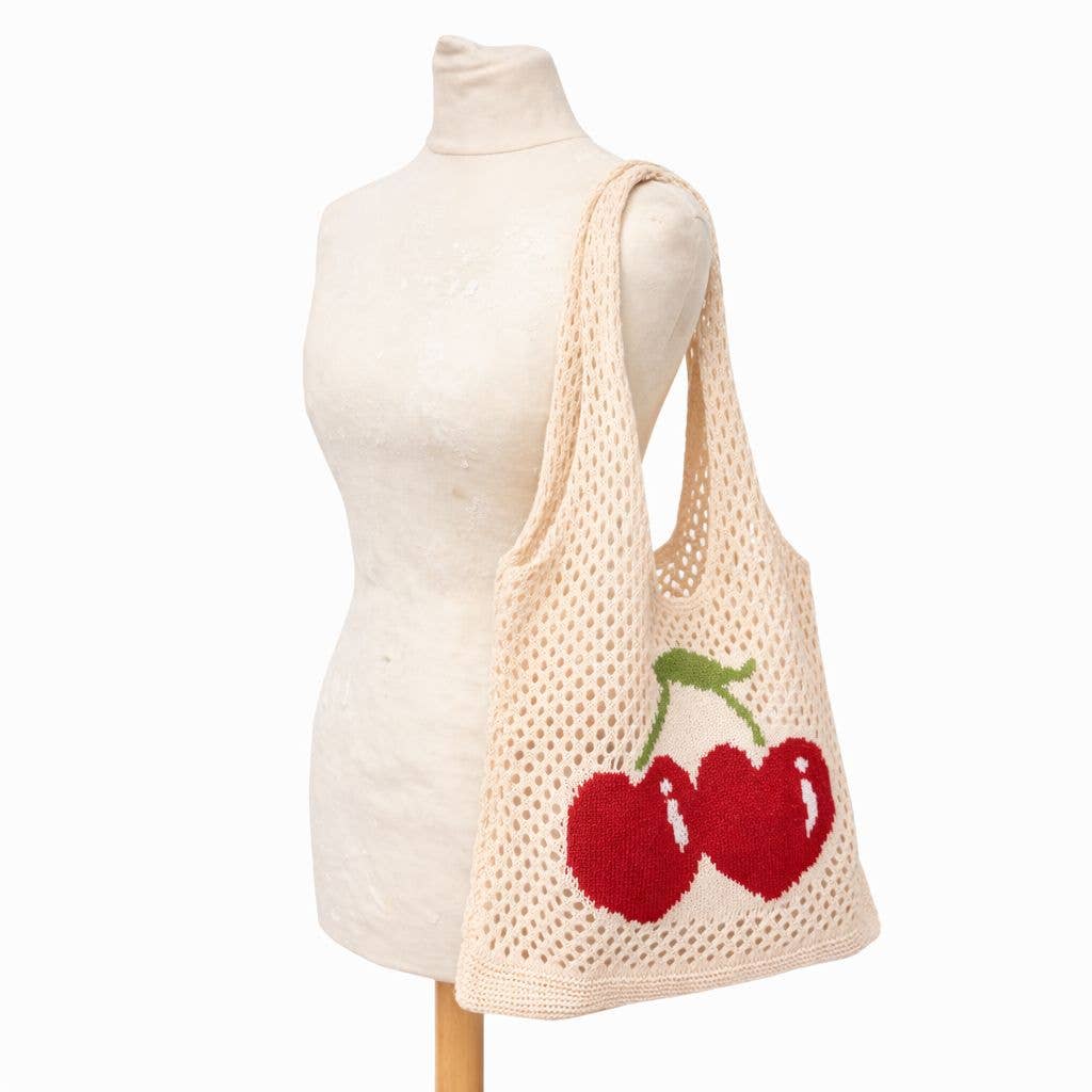 Knitted tote bag with cherry design on a mannequin against a white background