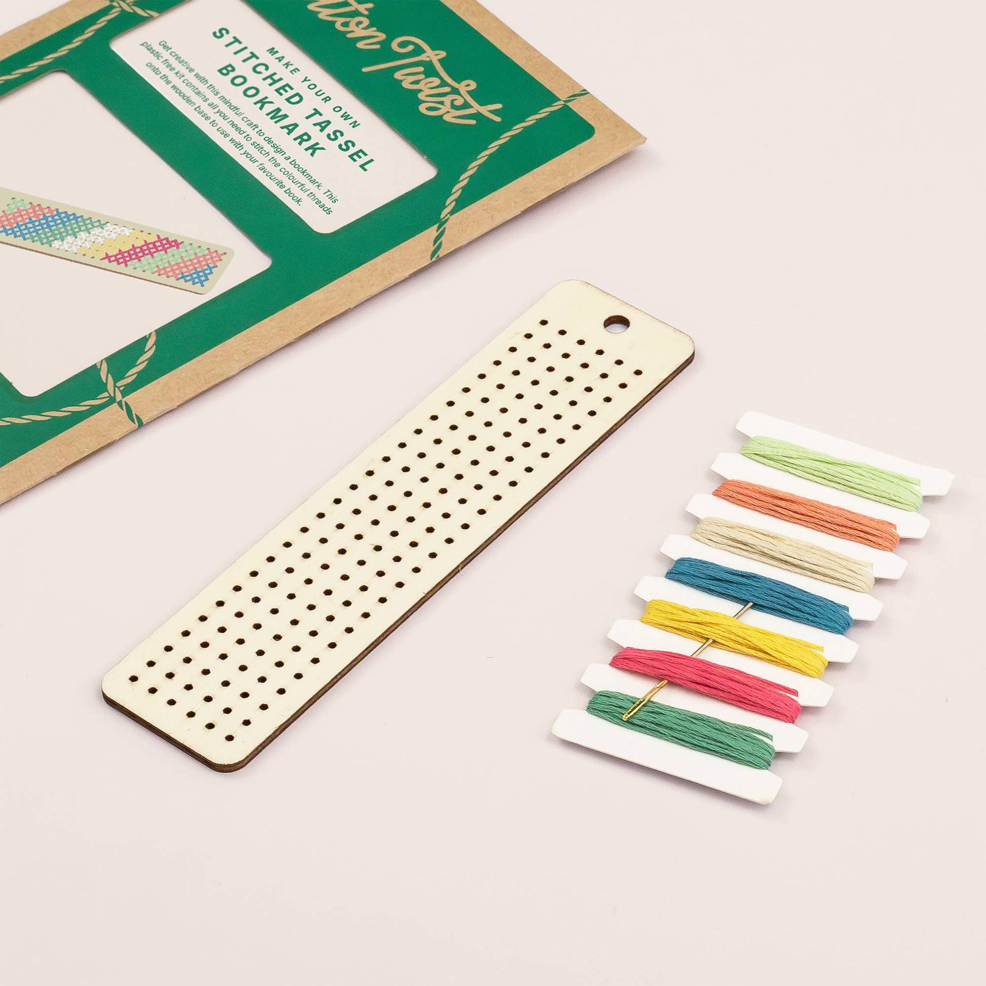 Wooden bookmark with threaded colorful tassels on a light background