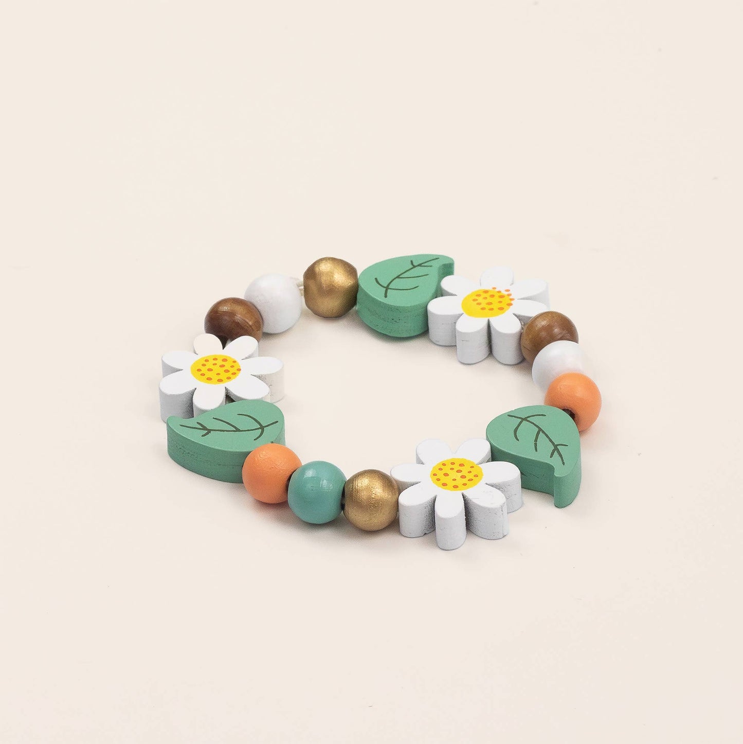 Colorful wooden bracelet with flowers and leaves on a beige background
