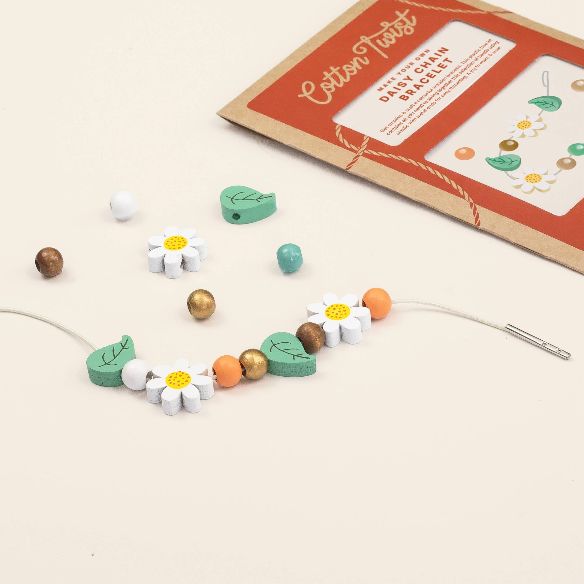 Children's jewelry set with wooden beads and floral designs on a beige background