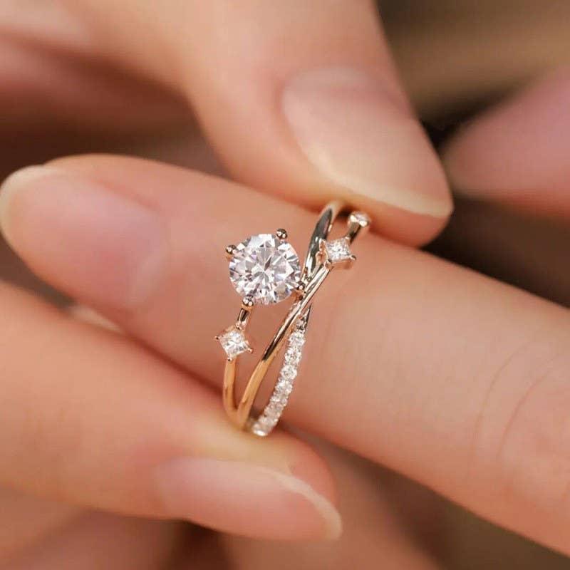 Rose gold ring with a diamond on a finger against a blurred background