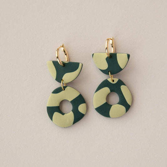 Green and beige patterned earrings on a beige background