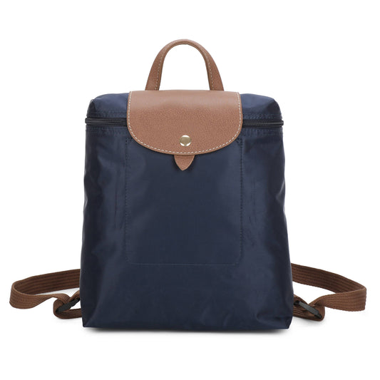 A navy blue nylon backpack with tan leather trim, a top handle, and adjustable shoulder straps, shown against a plain white background.
