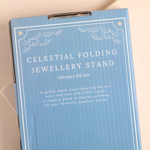 Blue box packaging for a celestial folding jewellery stand on a beige background