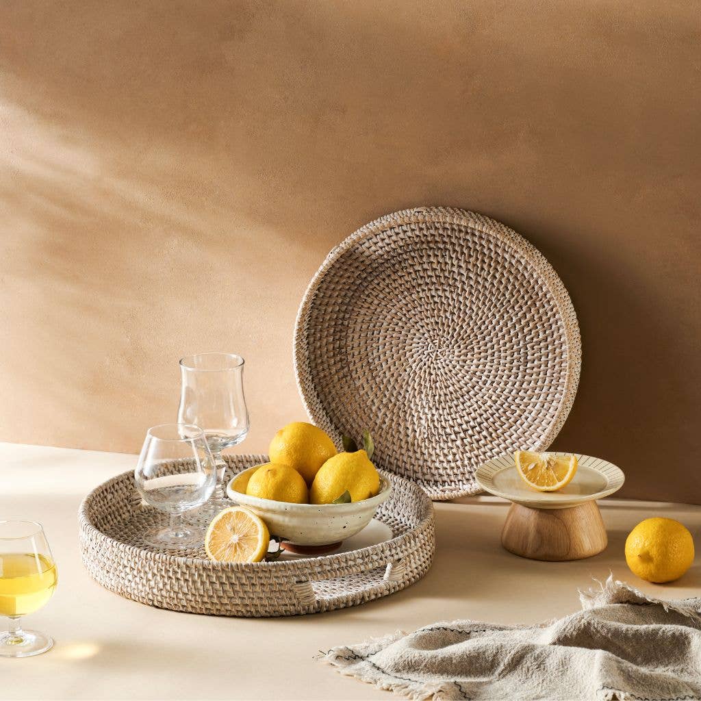 Woven plates and bowls with lemons on a neutral background