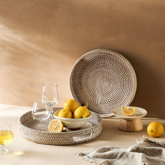 Woven plates and bowls with lemons on a neutral background