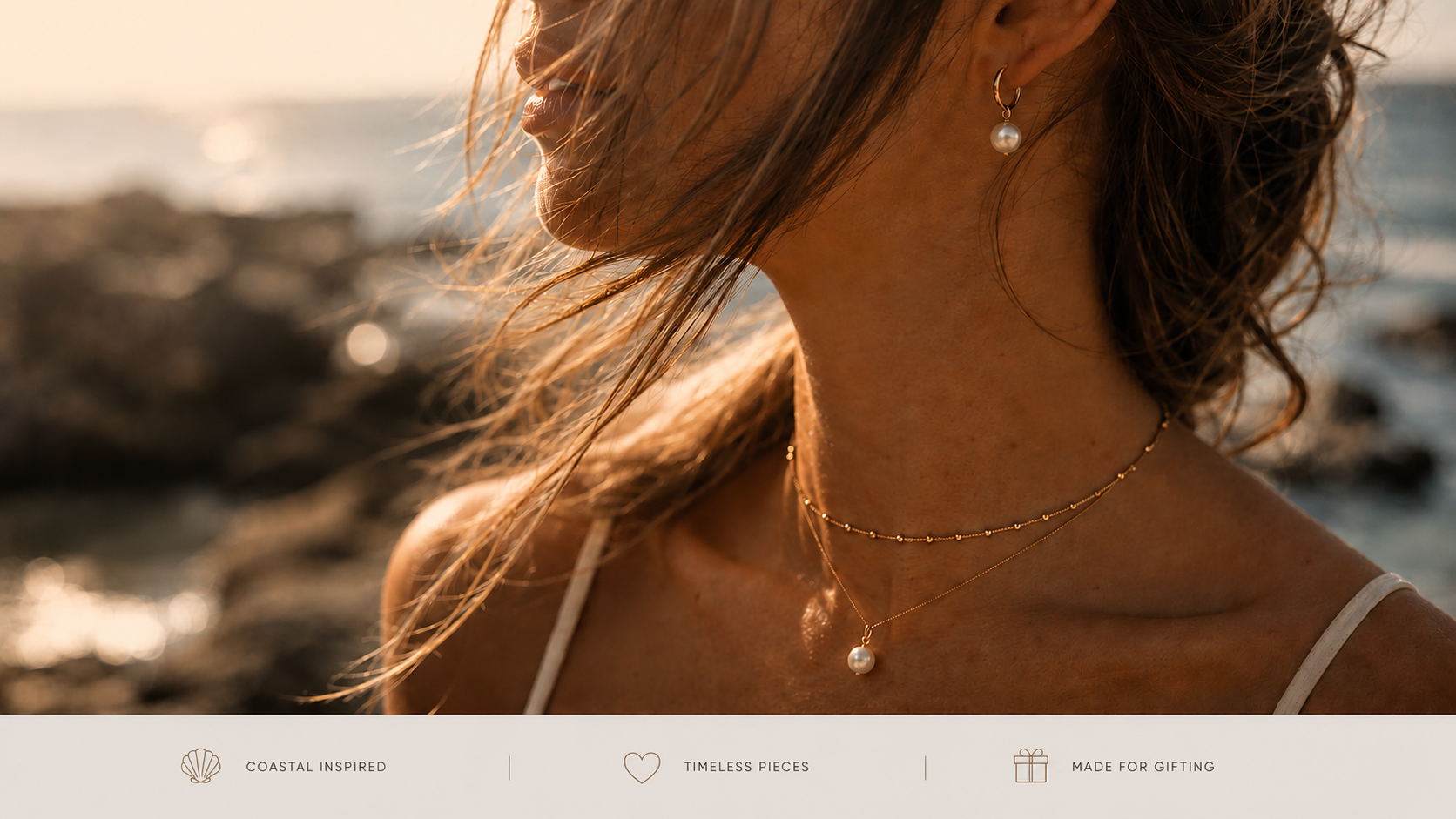 Woman wearing a necklace by the ocean with a blurred background