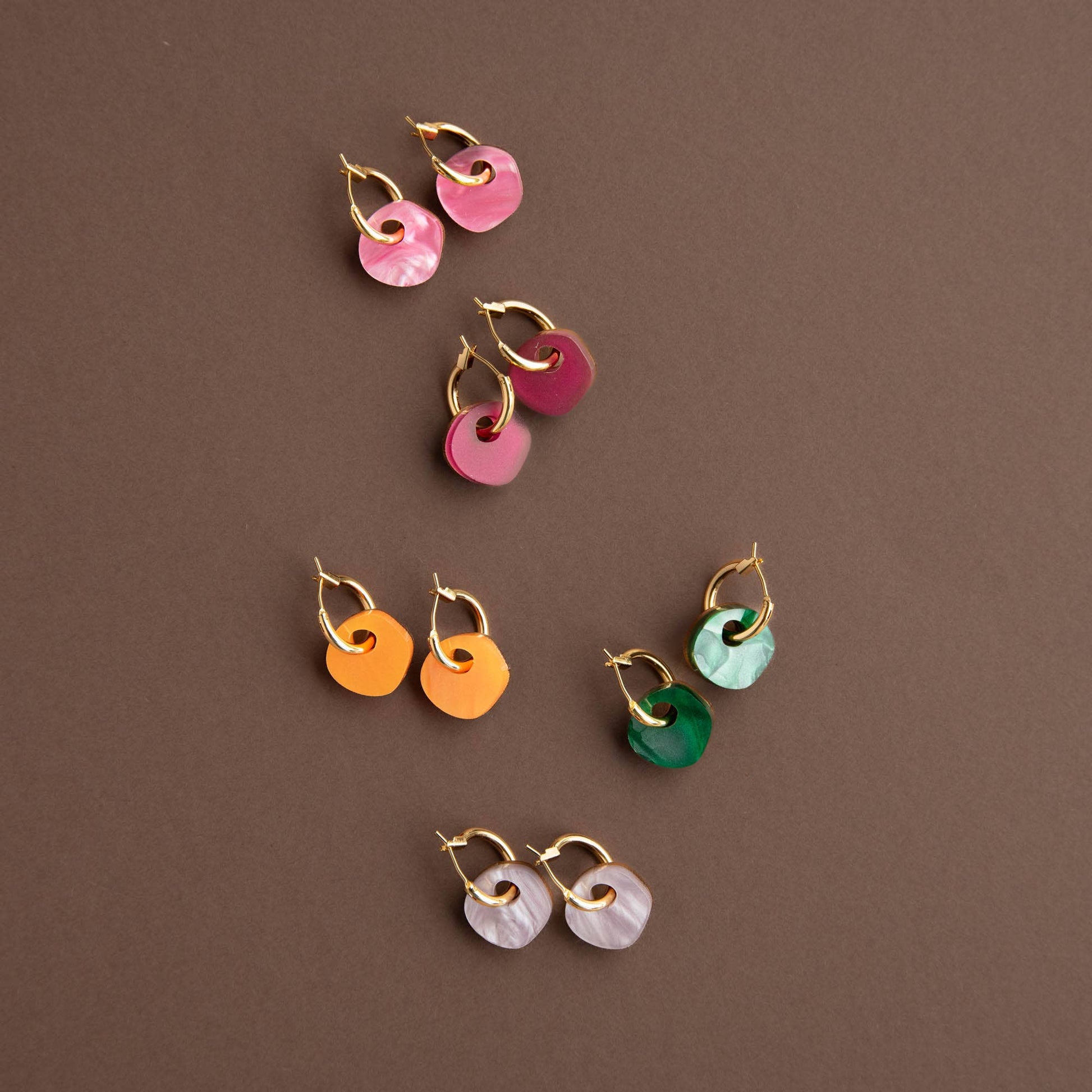 Set of colorful earrings on a brown background