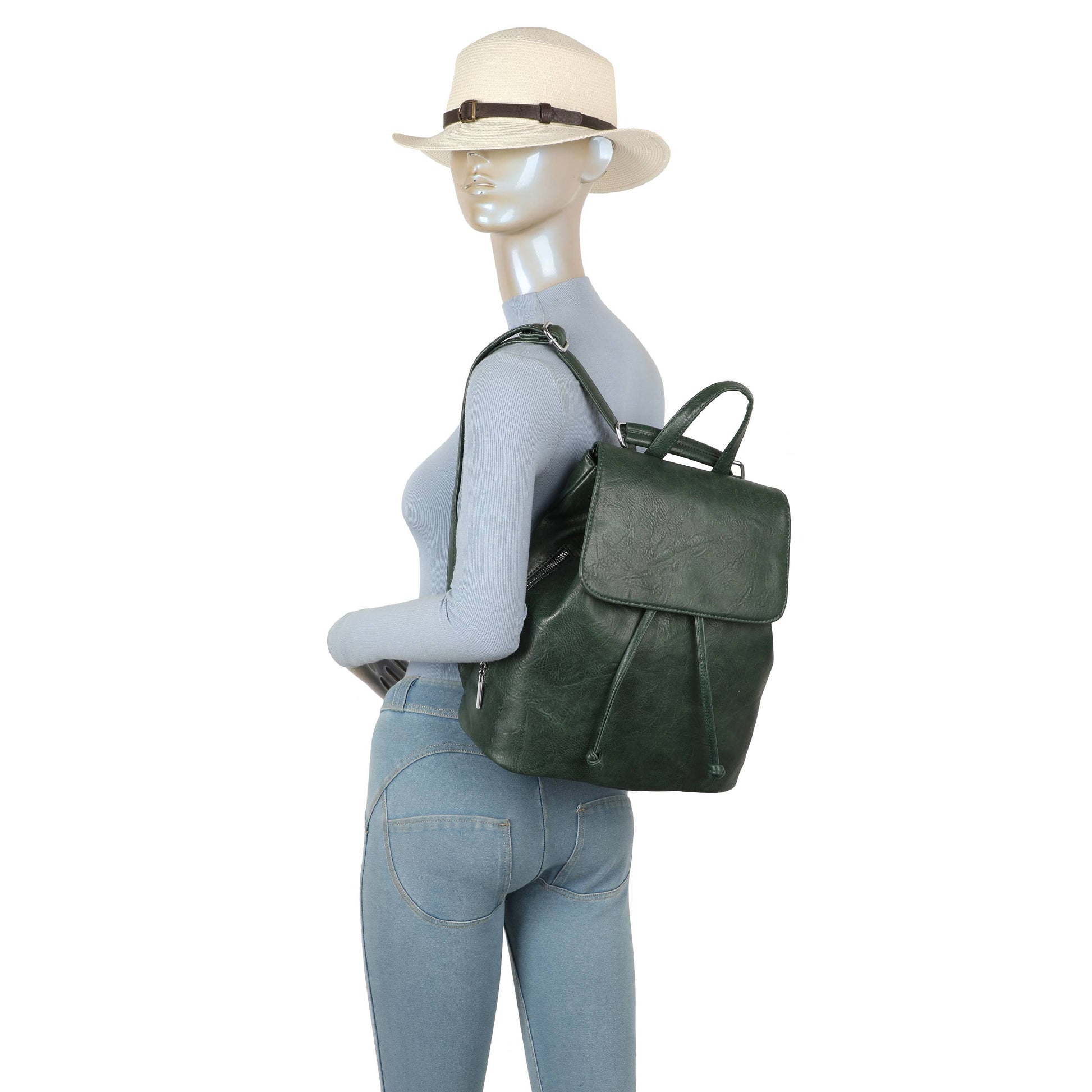 Mannequin wearing a green leather backpack and light-colored hat on a white background