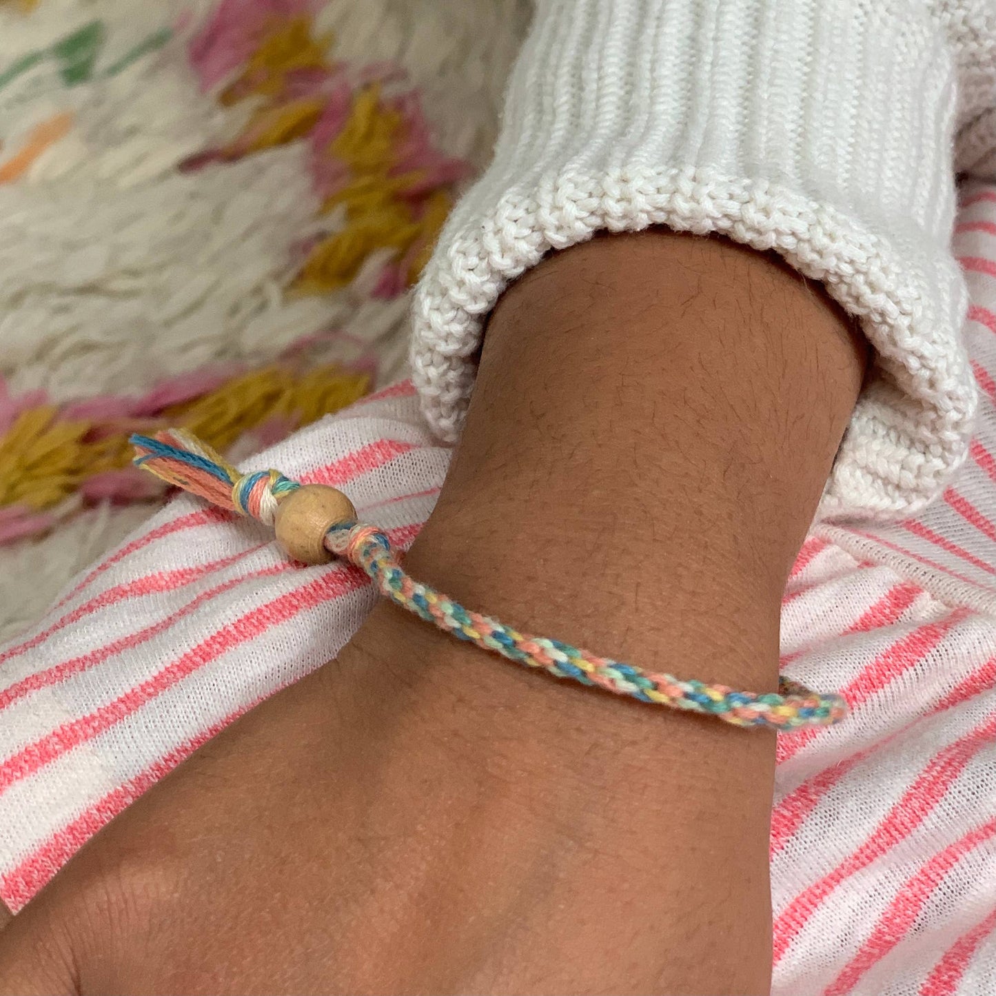Colorful braided bracelet on a wrist with a blurred background